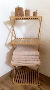 a wooden shelf with towels and baskets on it at Jolie maison, plain-pied à Dole in Dole +20 photos
