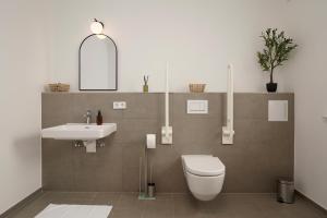 a bathroom with a toilet and a sink at Wohnkultur - Ferienhaus für 10 auf 140qm mit Garten in Wiesloch +16 photos