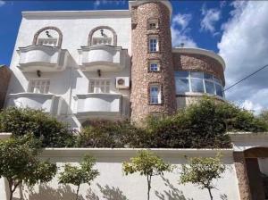 a building with a tower on the side of it at Beach apartment g in Sousse