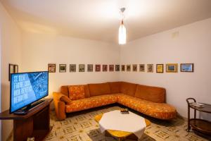 a living room with a brown couch and a television at Francesca's House, Ceto Ospitar in Ceto