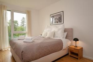 a bedroom with a bed with white pillows and a window at Wohnkultur - Ferienhaus für 10 auf 140qm mit Garten in Wiesloch