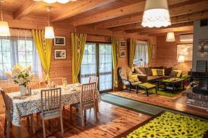 a living room with a table and chairs and a couch at Dom Marzeń z jacuzzi pod gwiazdami in Kopalino