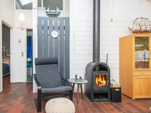 a living room with a fireplace and a chair at 4 person holiday home in Aabenraa in Aabenraa +38 photos