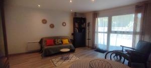 a living room with a couch and a window at Studio le Gabizos in Mirepeix