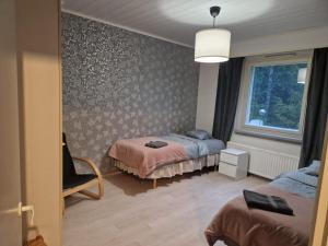 a bedroom with two beds and a window at Asunto työporukalle Myllymäki 25 with free parking in Lahti