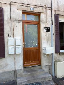 una puerta de madera en el lateral de un edificio en Maison Yuki - Rose Velours - Netflix & Parking, en Le Mont-Dore