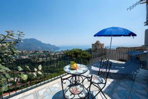 a patio with an umbrella and a table and chairs at A casa dei nonni in Scala