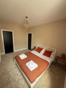 a bedroom with a large bed with two towels on it at Stylish and Bright 2 Bedroom Flat Free Parking in Wallasey +11 photos