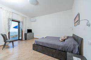 a bedroom with a bed and a chair and a window at A casa dei nonni in Scala