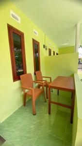 a room with two chairs and a table and a table and chairs at Mango Lodge in Gili Gede