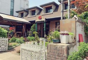 a house with a white fence and some plants at Cozy Erin Stay, Seoul in Seoul
