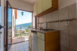 a kitchen with a view of a balcony at Apartments and Bungalows Mimoza Baošići in Herceg-Novi
