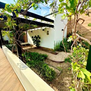 einen Garten mit einer weißen Wand und einigen Pflanzen in der Unterkunft Depto amoblado 2 dormitorios Equipetrol in El Pary