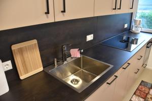 a kitchen with a sink and a black counter top at Gästehaus in Thüringen in Thüringen +20 photos