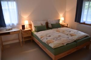 a bedroom with a bed with a desk and two lamps at Gästehaus in Thüringen in Thüringen