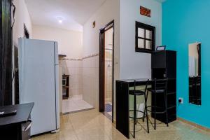 a kitchen with a refrigerator and a table in a room at Casa c Wi-fi e garagem a 5 min do centro in Maricá
