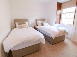 a bedroom with two beds and a window at Balsaggart Farm in Maybole