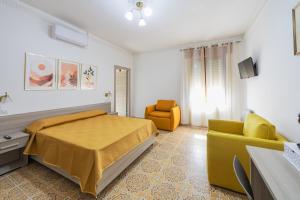 a bedroom with a bed and a yellow chair at Al numero 1 - Guest House in Nova Siri Marina