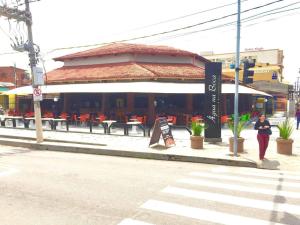 a woman standing on a sidewalk in front of a restaurant at Casa Bairro Bosque com 3 quartos in Rio Branco