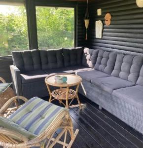 a living room with a couch and a table and chairs at Cooking Over Fire And Coziness Near Ajstrup Beach in Ajstrup Strand