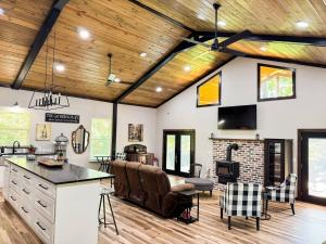 eine Küche und ein Wohnzimmer mit Holzdecken und einem Kamin in der Unterkunft Little River Retreat~Peaceful Countryside Getaway in De Queen