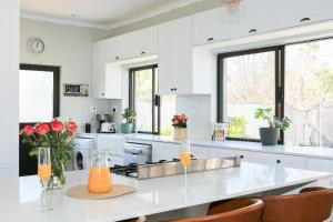 a kitchen with white cabinets and a white counter top at Kirrin Cottage in Benoni in Benoni