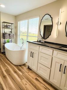 ein Badezimmer mit Badewanne und großem Spiegel in der Unterkunft Little River Retreat~Peaceful Countryside Getaway in De Queen + 33 Fotos
