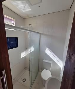 a bathroom with a toilet and a glass shower at Casa com piscina 03 quartos até 10 pessoas in Rio Branco