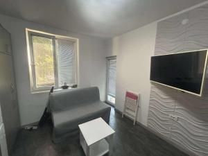 a living room with a couch and a flat screen tv at Нощувки Шумен in Shumen