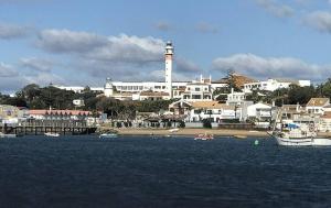 a city with a lighthouse and boats in the water at Casa Junto a la Playa in El Rompido