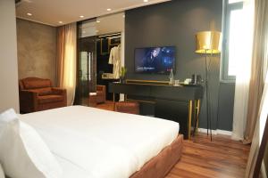 a bedroom with a bed and a desk with a television at La Suite Boutique Hotel in Tirana