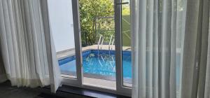 a view of a swimming pool through a window at Itria private pool villa in Pinangode
