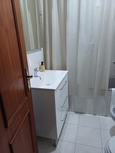 a bathroom with a white sink and a shower at Casa Na Vila in Vila Pouca de Aguiar +25 photos