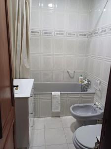 a bathroom with a toilet and a sink and a tub at Casa Na Vila in Vila Pouca de Aguiar
