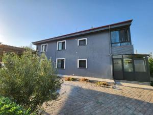a gray house with windows and a brick driveway at Kabaklı Konaklama Turizm Amaçlı Kiralık Konut in Kabaklı