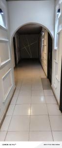 an empty hallway with a white tile floor and doors at AP Luxury Inn in Idowu
