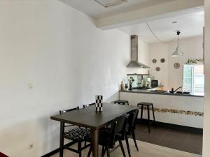 une cuisine et une salle à manger avec une table et des chaises dans l'établissement "La Liberté" Maison de ville, Parking, Wi-Fi, à Sète