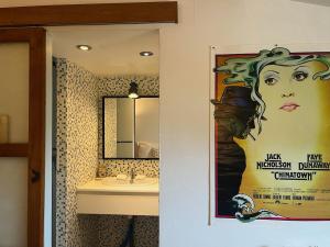 une salle de bain avec une affiche d'une femme avec un pot dans l'établissement "La Liberté" Maison de ville, Parking, Wi-Fi, à Sète 25 autres photos