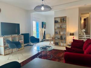 - un salon avec un canapé rouge et des fauteuils bleus dans l'établissement "La Liberté" Maison de ville, Parking, Wi-Fi, à Sète