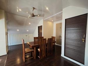 a dining room with a wooden table and chairs at kangri cottage in Srinagar