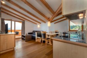a kitchen and living room with a couch and a table at Das Moriggl in Malles Venosta