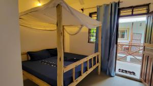 a bedroom with a bunk bed with a canopy at Mufassa Beach Hotel in Jambiani