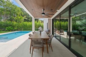 a dining room with a table and chairs next to a swimming pool at Absolut Luxe 5 Bed Villa with Pool- Great for Group in North Miami Beach