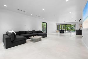 a living room with a black couch and a table at Absolut Luxe 5 Bed Villa with Pool- Great for Group in North Miami Beach