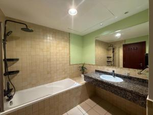 een badkamer met een bad, een wastafel en een spiegel bij Simbad Friendly Coliving in Dubai +27 foto's