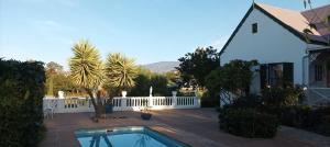 a house with a swimming pool and a white fence at Villa Ulrika - McGregor in McGregor