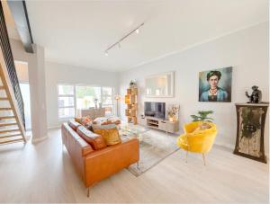 a living room with a couch and a tv at Coastal Bliss Getaway Awaits! in Keurboomstrand