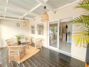a patio with a table and chairs on a porch at Coastal Bliss Getaway Awaits! in Keurboomstrand
