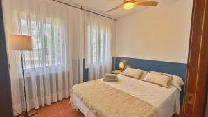 a bedroom with a bed with a blue headboard and a window at Nomad Haux in the heart of Tossa 9 in Tossa de Mar