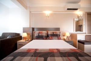 a bedroom with a bed and a couch and two lamps at Atrium Apart Otel in Altınyunus +41 photos